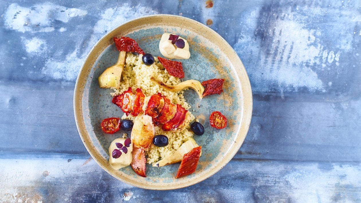 Couscous met artisjokken, zongedroogde tomaten en taggiasche olijven, gegrilde kreeft en ananaskerriesaus – Recept