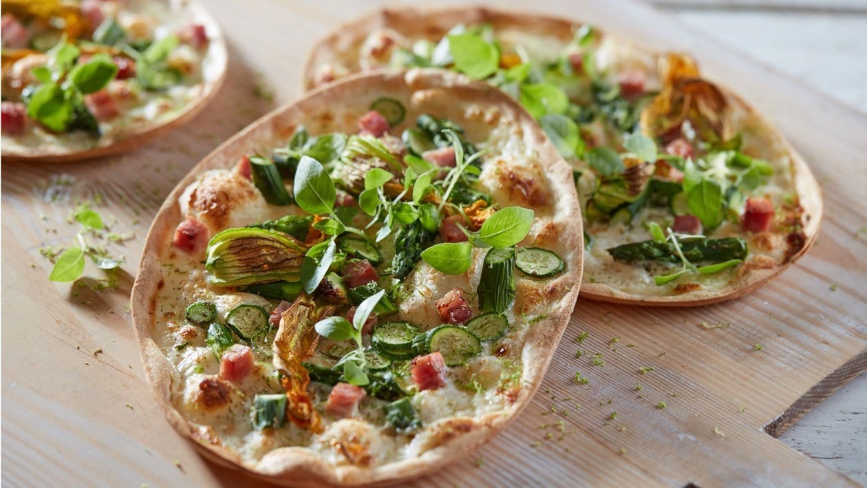 Flammkuchen, asperges, roomkaas en courgettebloemen – Recept