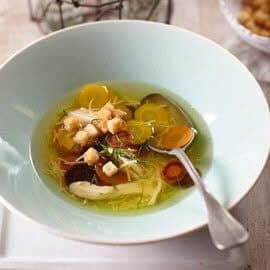 Heldere kippensoep uit Marokko met oerwortels en bladpeterselie