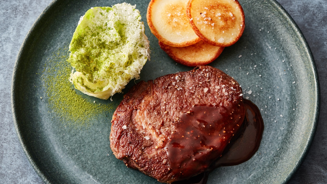 Ribe eye met kruidenboter en rode wijn saus, Caesar salade en aardappelpannenkoekjes – Recept
